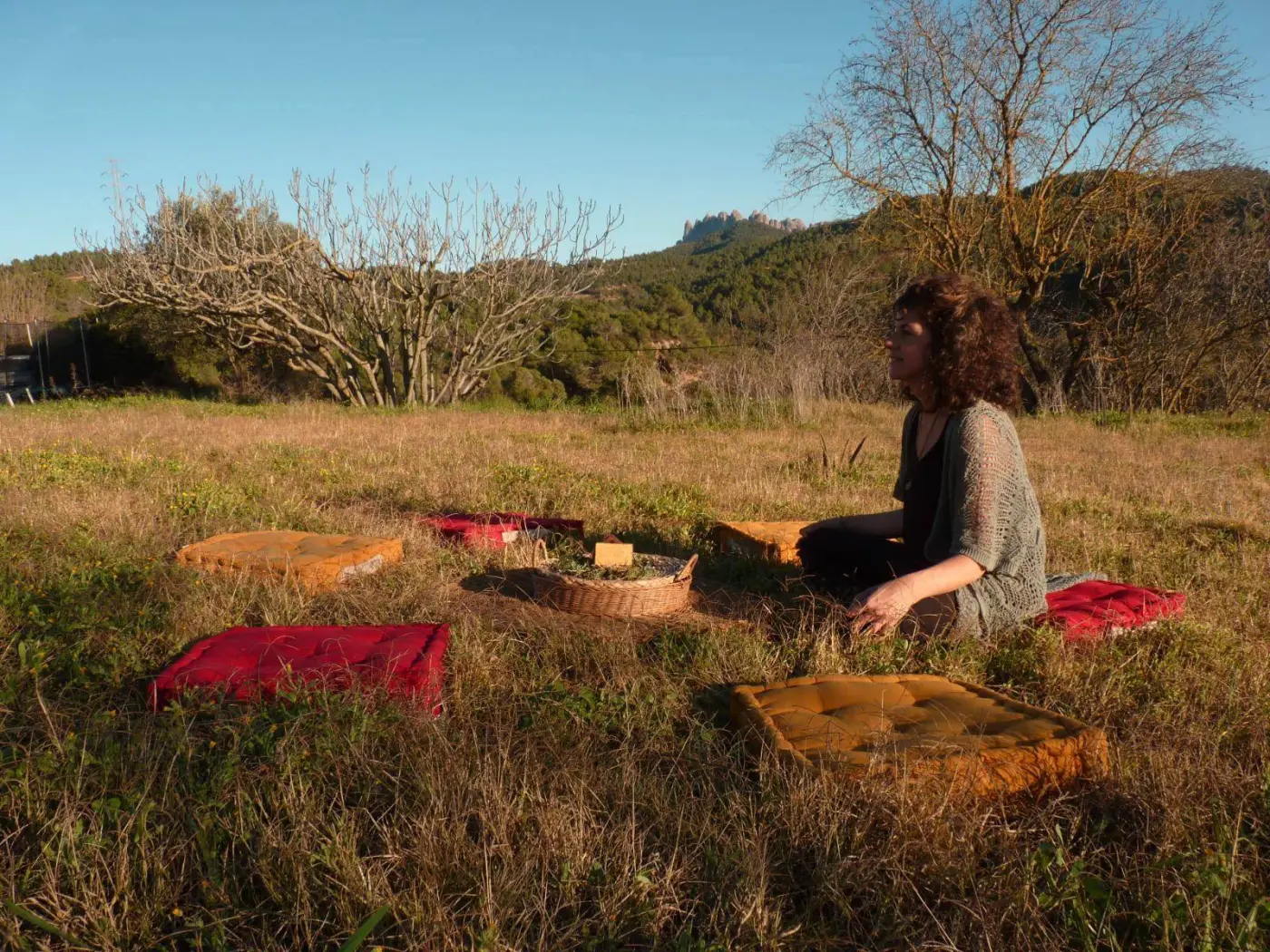 Espai de meditació a l’aire lliure amb coixins, amb Montserrat al fons